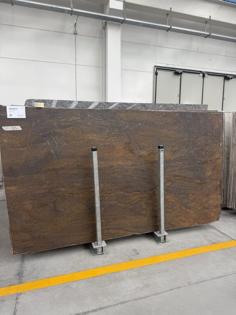 Bronzite natuursteenplaat met donkerbruine, bronzen en goudkleurige aders voor een eettafel op maat
